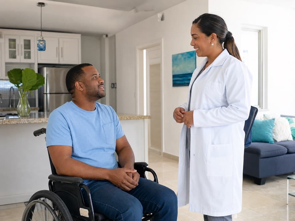 Profesional de laboratorio conversando con un paciente con movilidad limitada